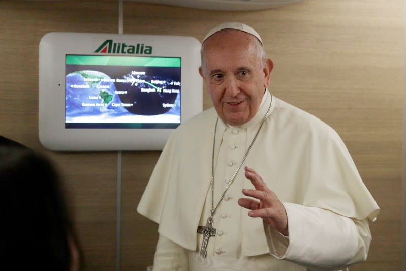 Pope Francis greets journalists aboard the papal plane en route to Bangkok