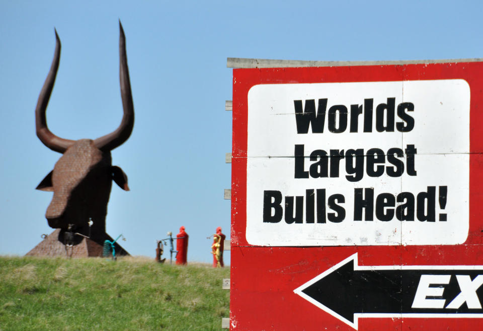 In this May 10, 2012 photo, an Interstate 90 billboard billing a bull's head sculpture as the world's largest sits at the edge of Porter Sculpture Park, in Montrose, S.D. The park’s signature piece is a 60-foot-tall Egyptian-style bull’s head that stares down Interstate 90 motorists as they head out to South Dakota’s Black Hills. Wayne Porter spent three years creating the 25-ton monstrosity out of railroad tie plates, dubbing it “The World’s Largest Bull’s Head” on a nearby billboard. (AP Photo/Dirk Lammers)