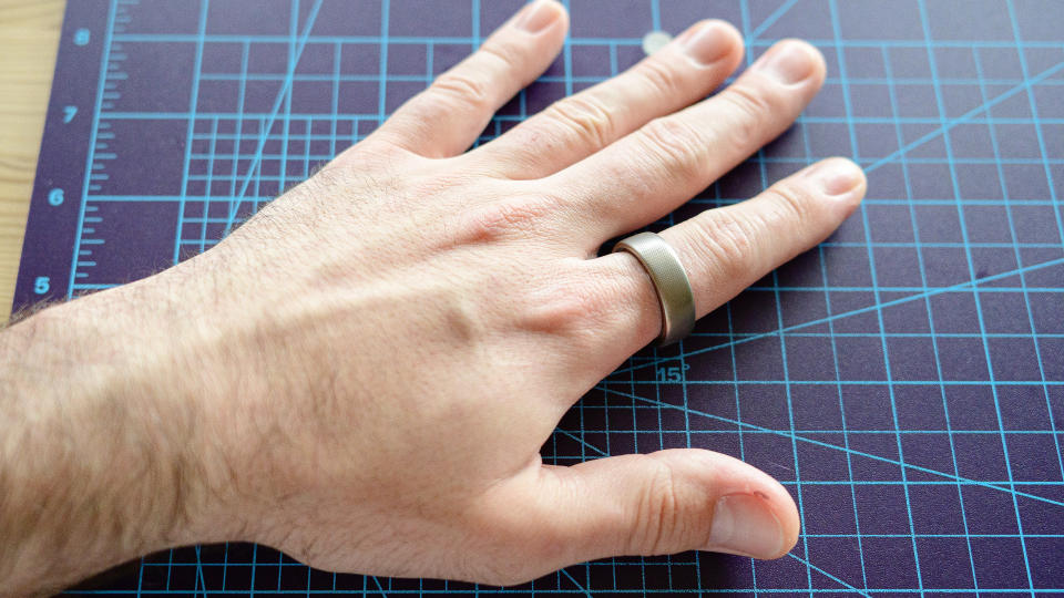 Amazfit Helio ring on a person's finger on a table