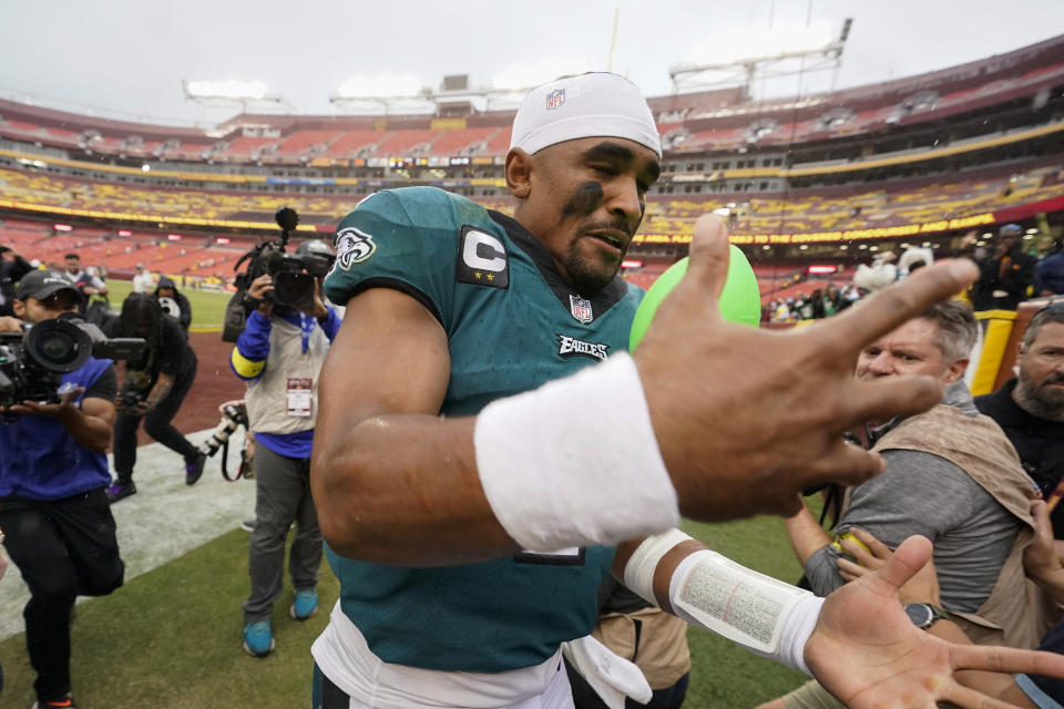 Philadelphia Eagles quarterback Jalen Hurts (1) catches a toy football thrown to him by a fans as he heads off the field at the end of an NFL football game against the Washington Commanders, Sunday, Sept. 25, 2022, in Landover, Md. Eagles won 24-8. (AP Photo/Alex Brandon)