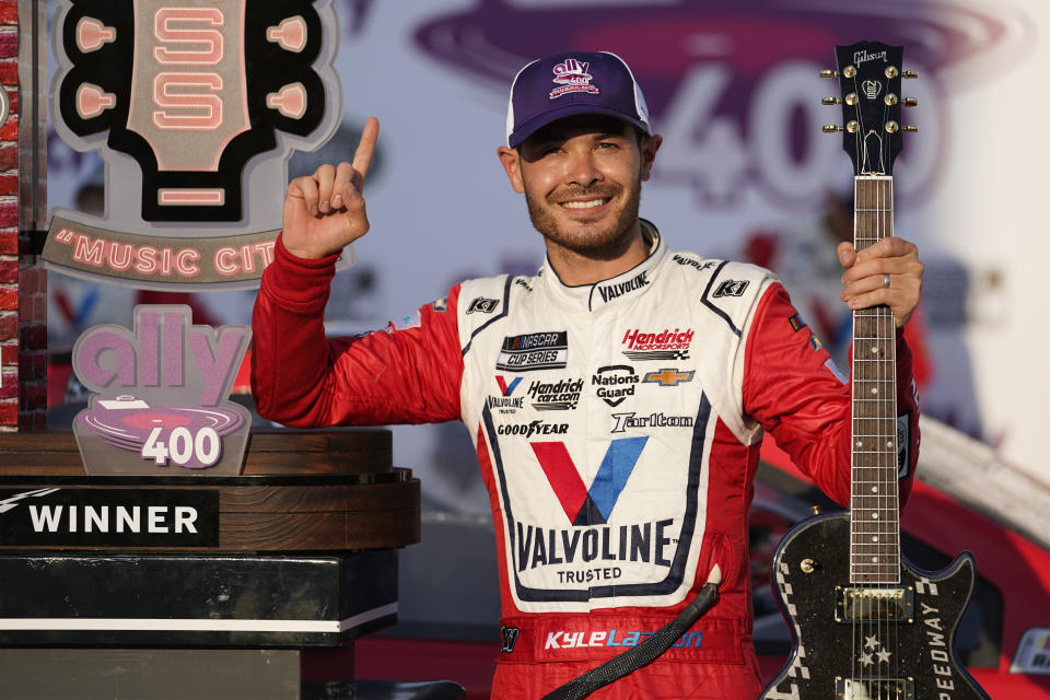 FILE - Kyle Larson celebrates with the winner's guitar and trophy after winning a NASCAR Cup Series auto race at Nashville Superspeedway in Lebanon, Tenn., in this Sunday, June 20, 2021, file photo. Rick Hendrick gave Kyle Larson a second chance in NASCAR because Hendrick Motorsports had wanted him in its lineup for years. Now that Hendrick has his man, he's locked Larson down for two more seasons with full sponsorship. Hendrick on Wednesday, July 14, told his 93 dealerships that the hottest driver in motorsports signed a contract extension through 2023 and Larson will be fully sponsored by HendrickCars.com. (AP Photo/Mark Humphrey, File)