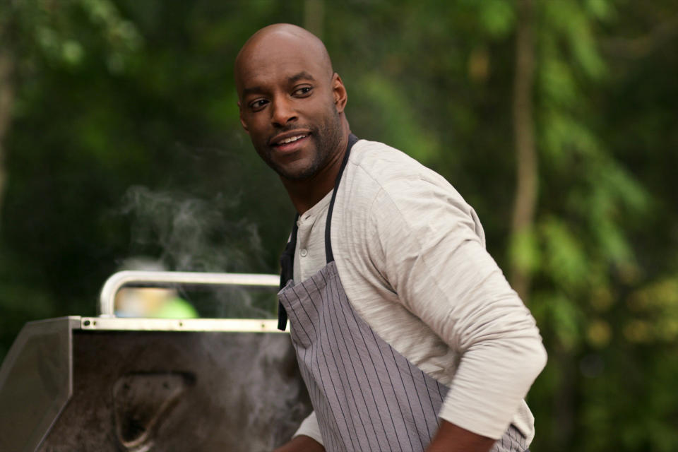 Preacher cooking on a barbecue wearing a striped chef's apron.