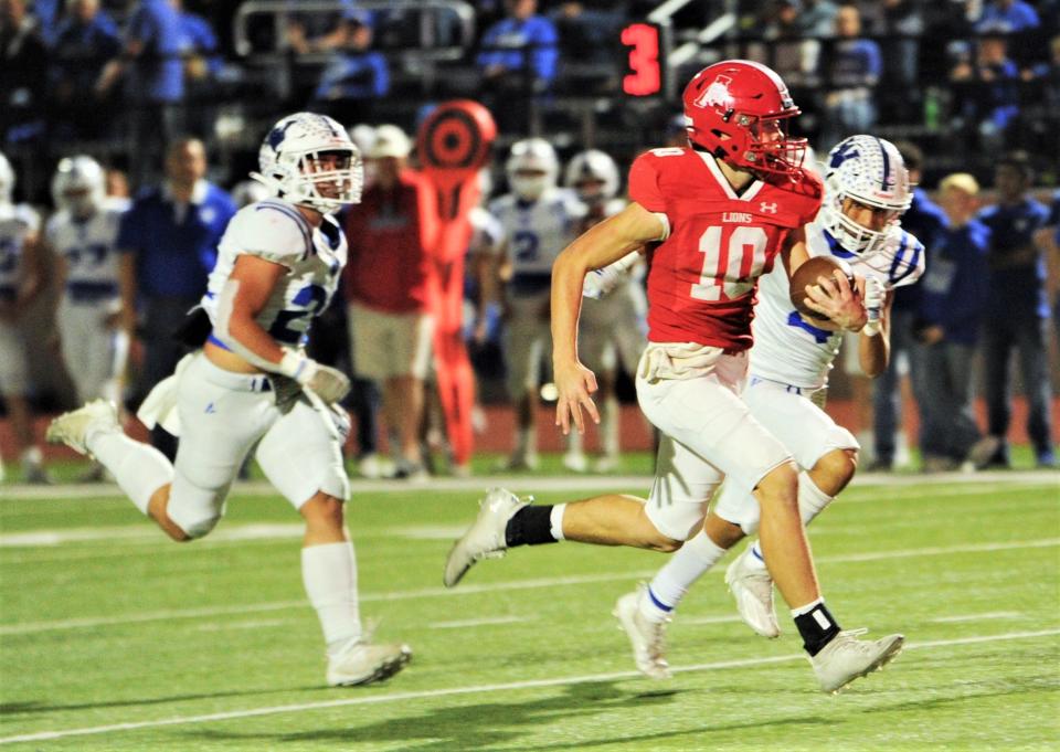 Albany quarterback Cole Chapman (10) outruns Windthorst's Clay Hoff, left and Moises Quiroz-Cruz, right, for a 34-yard touchdown run. The TD gave the Lions a 14-0 lead with 7:09 left in the first quarter.