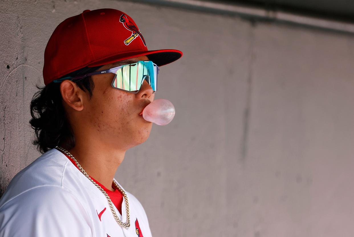 St. Louis Cardinals player Won-Bin Cho (80) blows a bubble in the dugout against the Houston Astros in the third inning at Roger Dean Chevrolet Stadium in Jupiter, Florida.