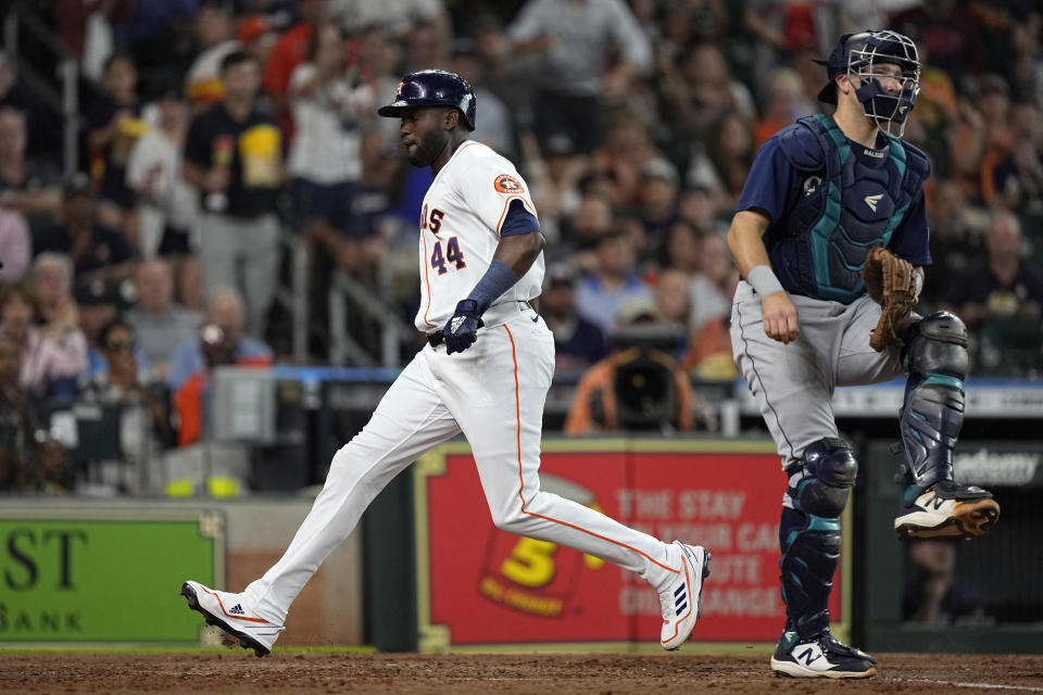 Houston Astros' Yordan Alvarez (44) scores as Seattle Mariners catcher Cal Raleigh covers home plate during the third inning of a baseball game Wednesday, June 8, 2022, in Houston. (AP Photo/David J. Phillip)