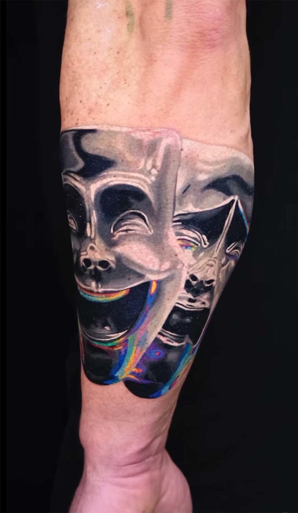 An image of Alan Ritchson's tattoo featuring the two overlapping masks the ancient Greeks used to represent comedy and tragedy, done by Toronto-based artist Pavlo Pozhydaiev aka Pasha Ink.