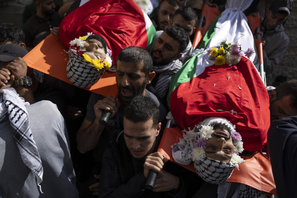 Mourners carry the Bodies of Ibrahim Awad, right, and Mohammad Fawaqa, during their funeral in the West Bank city of Ramallah, Thursday, Oct. 19, 2023. Awad was killed during clashes with Israeli settlers near his home village of Dura al-Qara' and Fawaqa was killed during an Israeli army raid in the village of Qebia, west of Ramallah, while two other Palestinians were killed during Israeli army raids early morning in the occupied West Bank, Palestinian ministry of health said. (AP Photo/Nasser Nasser)