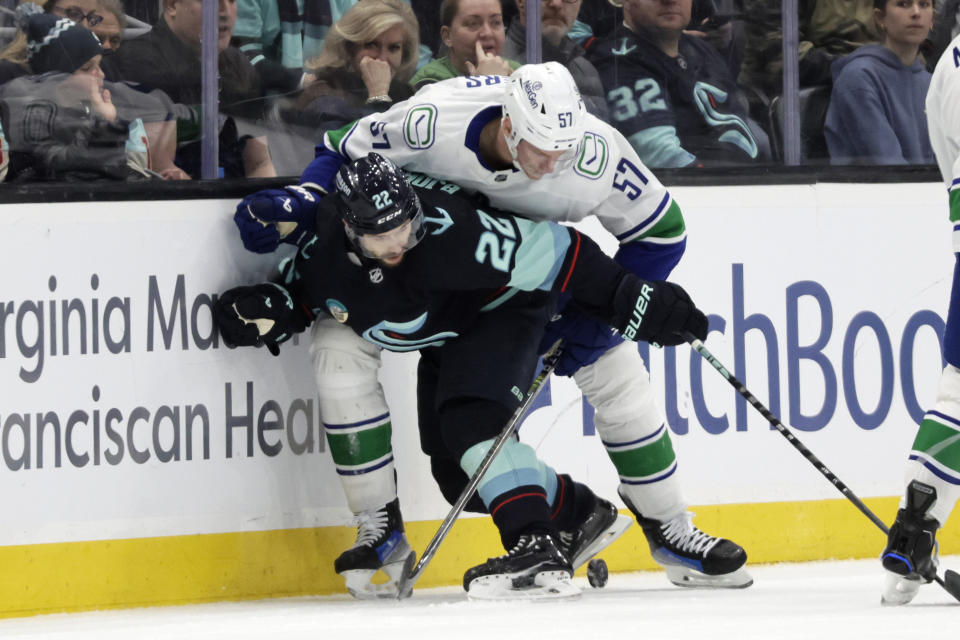 Seattle Kraken right wing Oliver Bjorkstrand battles with Vancouver Canucks defenseman Tyler Myers for the puck during the second period of an NHL hockey game, Thursday, Feb. 22, 2024, in Seattle. (AP Photo/John Froschauer)