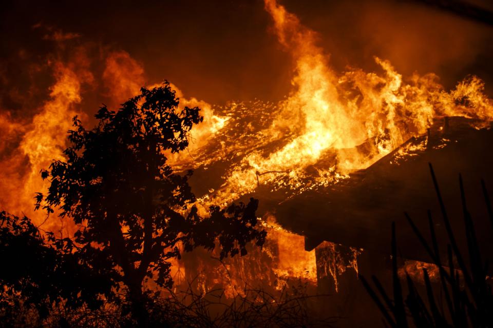 Flames&nbsp;consume a home as a brush fire sweeps through Oak View, a community in Ventura County, on Tuesday. (Photo: Marcus Yam/Los Angeles Times via Getty Images)