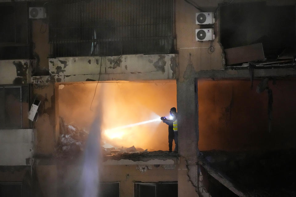 Civil defense workers search for survivors inside an apartment following a massive explosion in the southern suburb of Beirut, Lebanon, Tuesday, Jan. 2, 2024. The TV station of Lebanon's Hezbollah group says top Hamas official Saleh Arouri was killed Tuesday in an explosion in a southern Beirut suburb.(AP Photo/Hussein Malla)