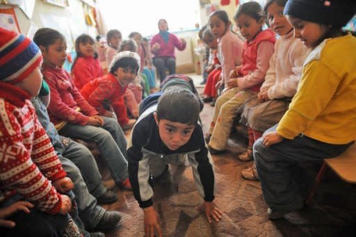 Romanian children, members of Roma community, play during class at the local kindergarten in Araci village, 200 kms north from Bucharest, in March 2012. A food coupon of about 12 euros a month ($15) is given to families living below the poverty level for each child who attends kindergarten daily -- a measure that has led to average 89 percent attendance records