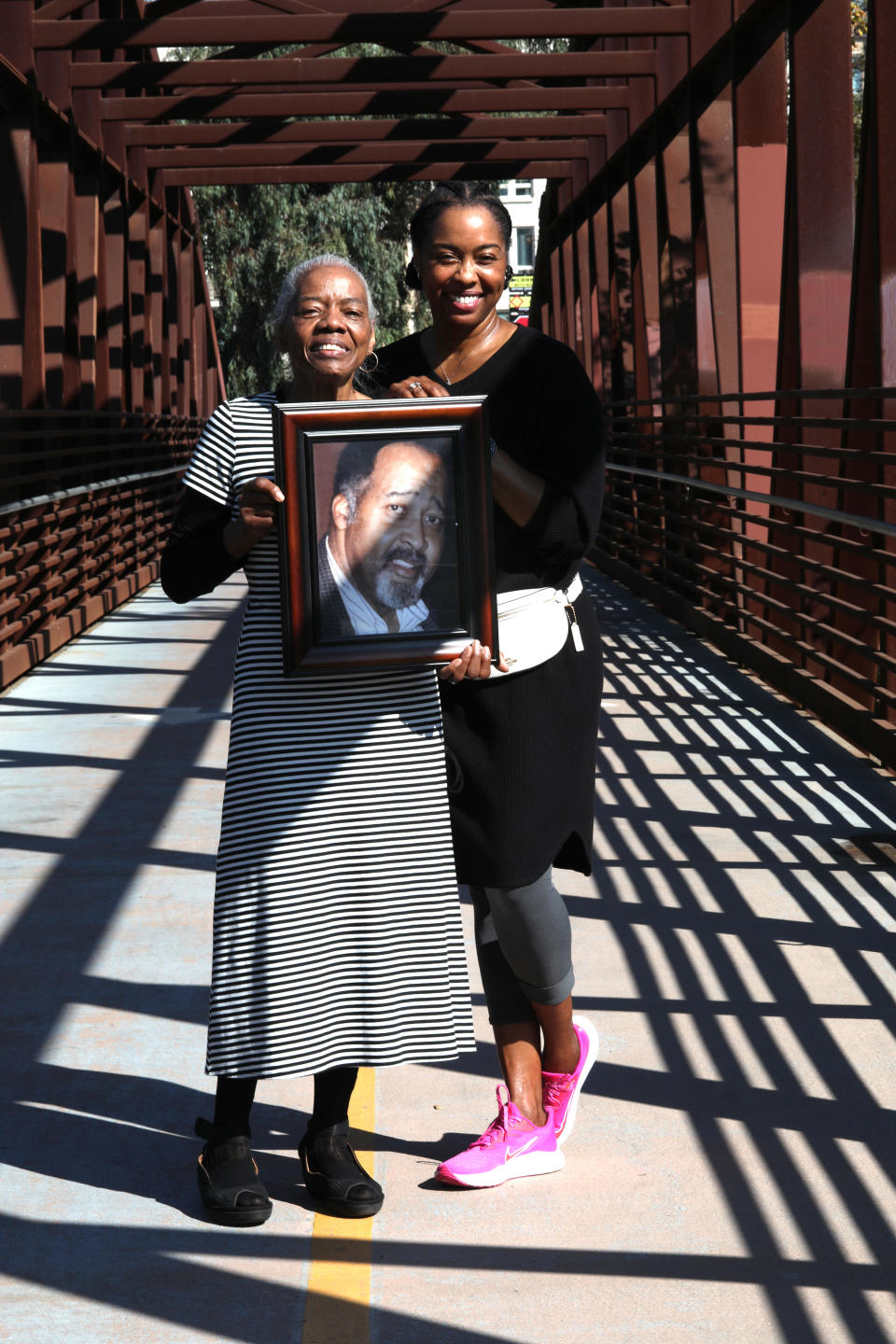 FILE -- Catherine Lawson (left) carrying a picture of her husband, Jerry Lawson, with her daughter Karen Lawson (right), on a bridge over the Guadalupe River on Nov. 5, 2020, in San Jose, Calif.  / Credit: Liz Hafalia/The San Francisco Chronicle/Getty Images  