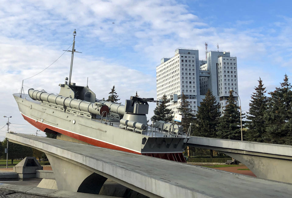 The building and the torpedo boat, the Baltic Sailors Memorial, in Kaliningrad, Russia, Thursday, Oct. 29, 2020. The hulking never-occupied building sardonically likened to a robot's head that has loomed over the city of Kaliningrad for decades is to be demolished next year, the region's governor says. The 21-story House of Soviets was left unfinished when funding ran out in 1985 amid the Soviet Union's economic struggles and later was assessed to be structurally unsound. (AP Photo/James Heintz)