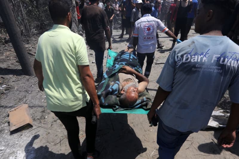 Emergency workers rush to attend to victims after an Israeli air strike on the Al-Mawasi camp for the displaced Palestinians. Abed Rahim Khatib/dpa