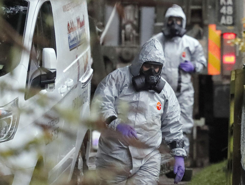 FILE - In this March 12, 2018 file photo personnel in protective gear work on a van in Winterslow, England, as investigations continue into the nerve-agent poisoning of Russian ex-spy Sergei Skripal and his daughter Yulia, in Salisbury, England. The Skripals fell ill and spent weeks in critical condition. They survived, but the attack later claimed the life of a British woman and left a man and a police officer seriously ill. Authorities said they both were poisoned with the military grade nerve agent Novichok. (AP Photo/Frank Augstein, File)