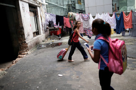 Children carry school bags at the abandoned Prestes Maia textile factory occupied by a homeless movement in downtown Sao Paulo, Brazil, May 8, 2018. REUTERS/Nacho Doce