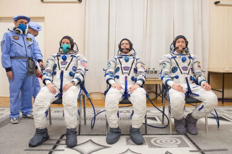 The International Space Station (ISS) crew members are pictured during space suit check at the Baikonur Cosmodrome