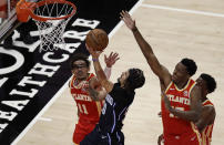 Orlando Magic guard Cole Anthony, center, shoots against Atlanta Hawks' Trae Young (11) and Onyeka Okongwu (17) in the first half of an NBA basketball game Tuesday, April 20, 2021, in Atlanta. (AP Photo/Ben Margot)