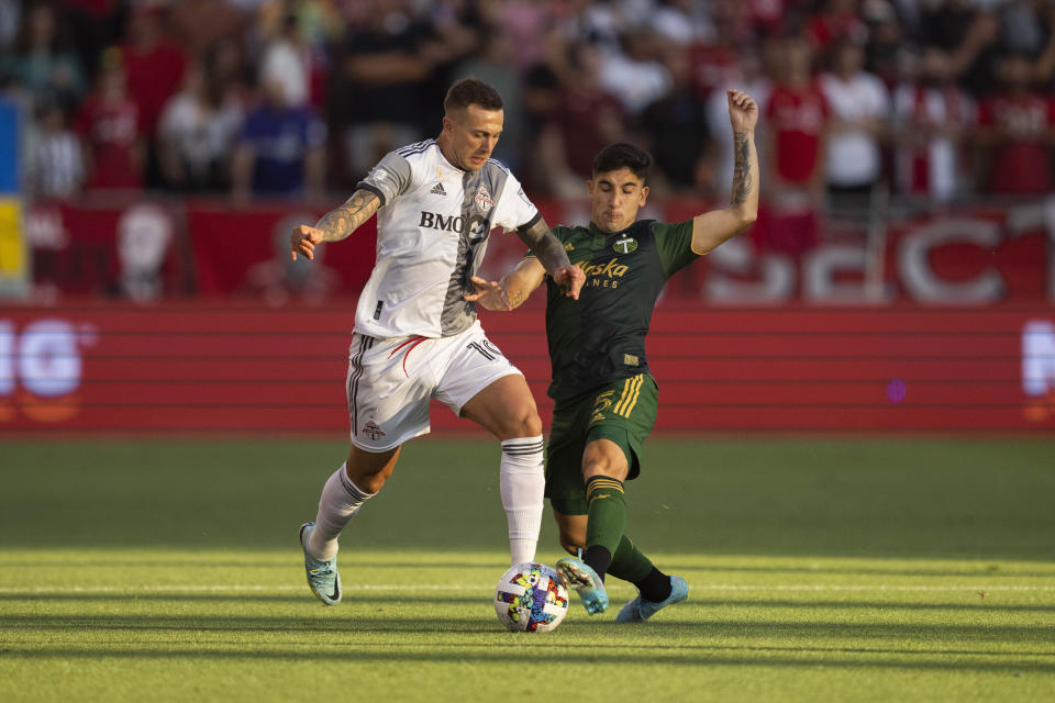 Toronto FC midfielder Federico Bernardeschi (10) battles for the ball against Portland Timbers defender Claudio Bravo (5) during first-half MLS soccer match action in Toronto, Saturday, Aug. 13, 2022. (Andrew Lahodynskyj/The Canadian Press via AP)