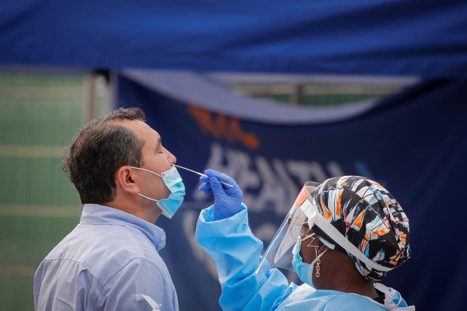 A health worker takes a swab sample from a man to test for the coronavirus disease (COVID-19) in the Borough Park area of Brooklyn, New York, U.S., September 25, 2020.  REUTERS/Brendan McDermid