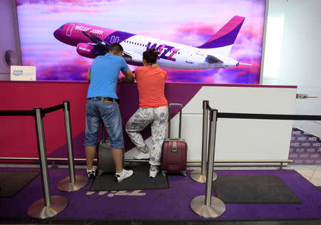 FILE PHOTO: Passengers talk to a Wizz Air desk clerk at Budapest Airport July 8, 2014. REUTERS/Bernadett Szabo