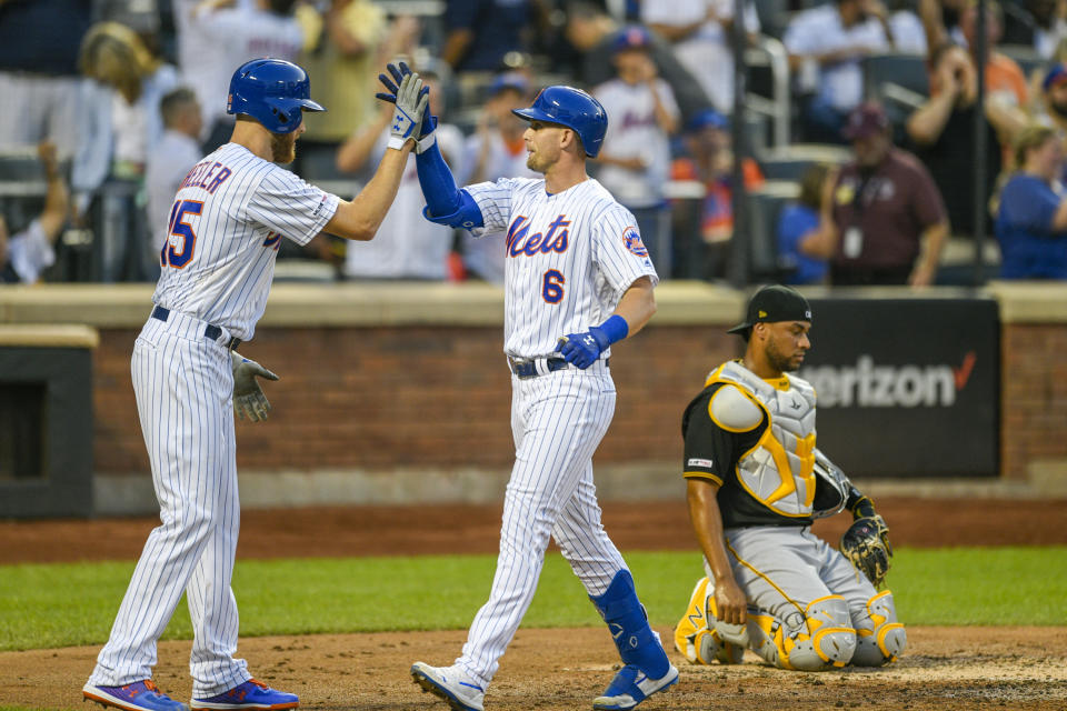 New York Mets Jeff McNeil, center celebrates a three run home run with New York Mets Zack Wheeler as Pittsburgh Pirates catcher Elias Diaz, right looks on during the third inning of a baseball game, Friday, July 26, 2019, in New York. New York Mets Amed Rosario also scored on the play. (AP Photo/Corey Sipkin)