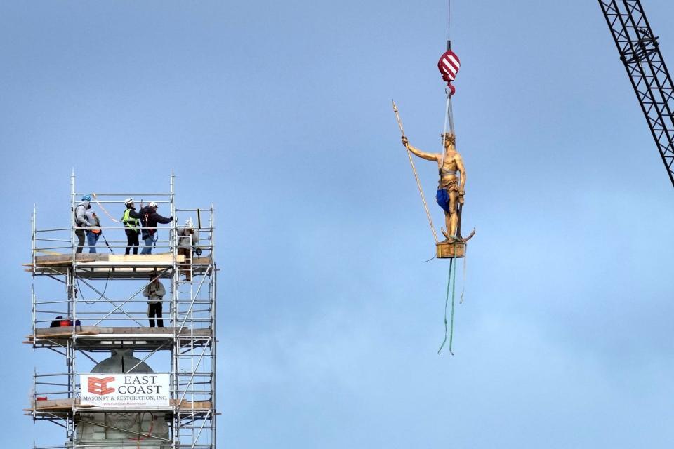The Independent Man is removed from the top of The State House in Providence, R.I. The 500-pound bronze statue, whose base has become cracked and unstable, is being taken down for repairs.