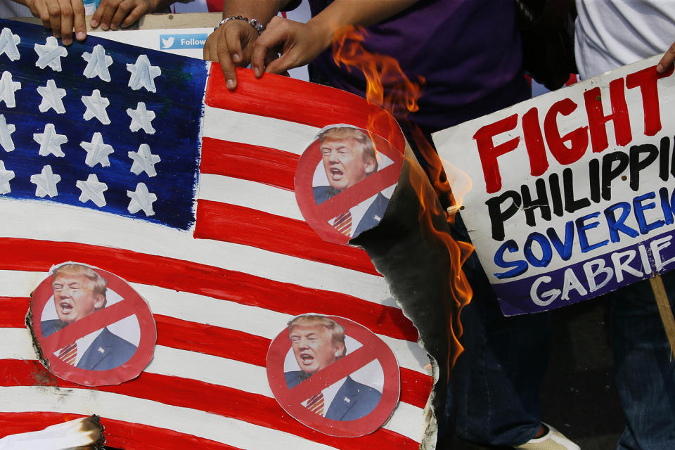 Protesters burn a mock U.S. flag