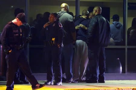 Police officers console each other outside the Prince George's Hospital Center where another officer, shot in the line of duty nearby, was later confirmed dead in Cheverly, Maryland March 13, 2016. REUTERS/Jonathan Ernst