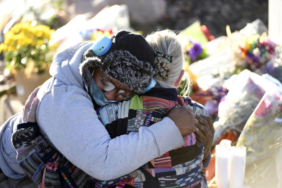 Justice Lord is comforted by a friend at a makeshift memorial.