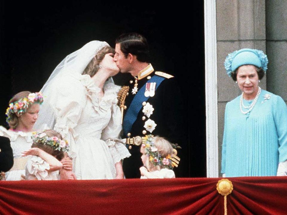 Princess Diana and Charles kiss on the balcony of Buckingham Palace after their wedding on July 29, 1981.