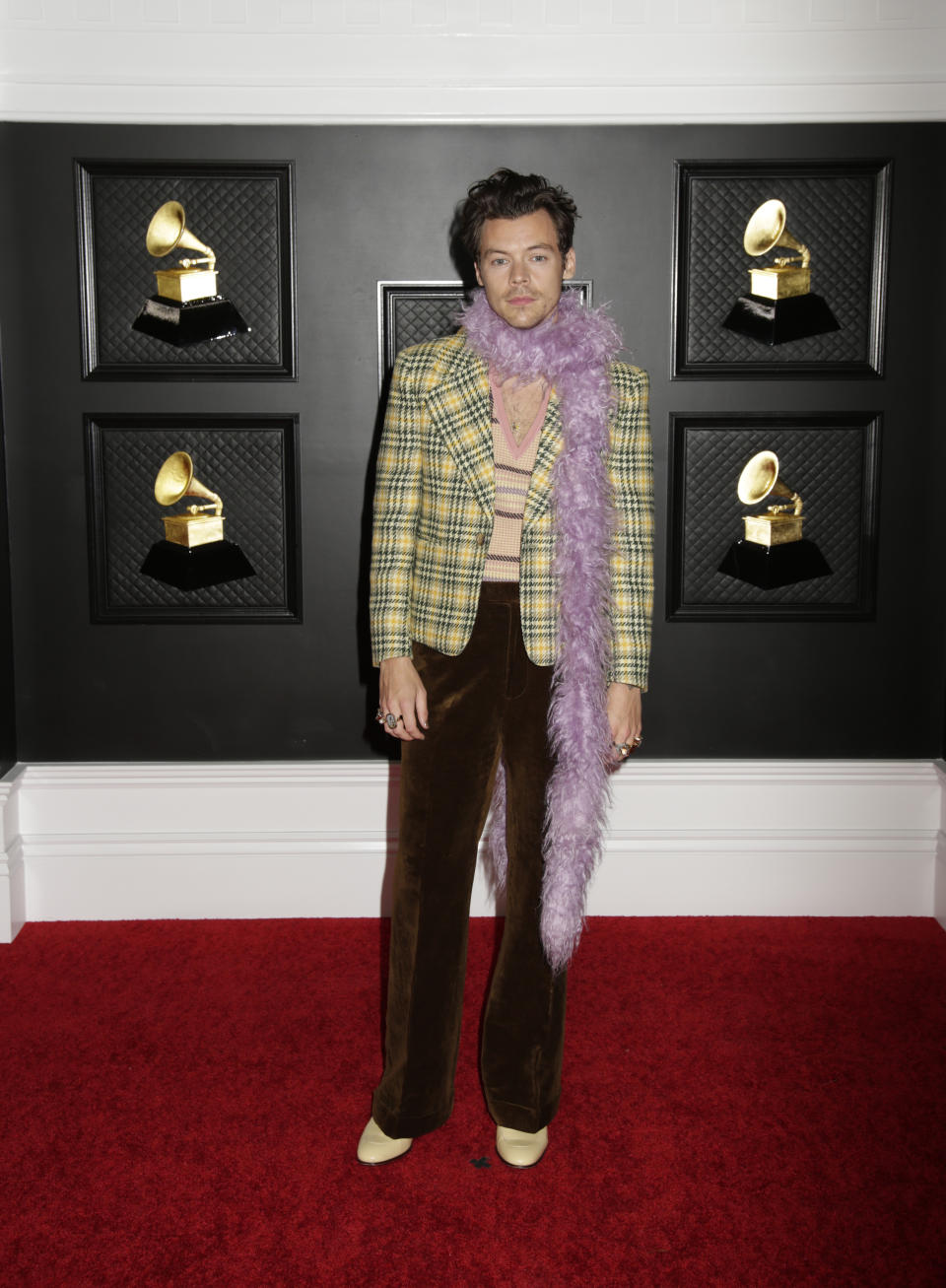 <p>Spätestens seit <a href="https://de.style.yahoo.com/harry-styles-vogue-cover-so-verteidigen-ihn-die-promis-im-netz-114847536.html" data-ylk="slk:seinem aufsehenerregenden Vogue-Cover;elm:context_link;itc:0;sec:content-canvas;outcm:mb_qualified_link;_E:mb_qualified_link;ct:story;" class="link  yahoo-link">seinem aufsehenerregenden Vogue-Cover</a> lässt sich Harry Styles in Sachen Mode nichts mehr vorschreiben - glücklicherweise! Mit seinem Grammy-Look von Gucci macht er eigenhändig Strickpullunder, Karo-Blazer und Samthosen im Retro-Look wieder salonfähig und kombiniert dazu androgyne Elemente wie eine Federboa. (Bild: Francis Specker/CBS via Getty Images)</p> 