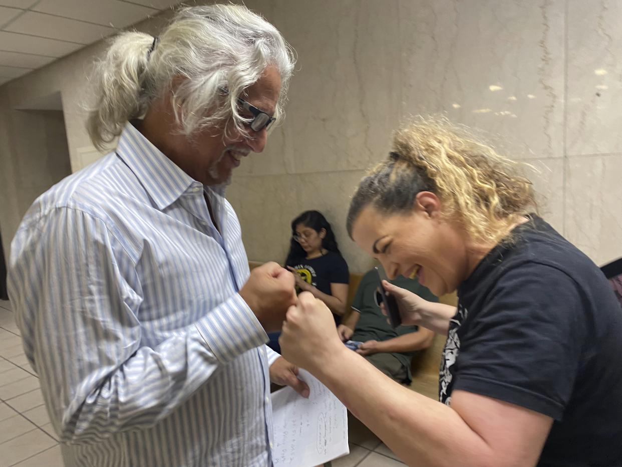 Phillip Picone, left, and Shere Dore fist bump after Picone is found not guilty for breaking a law against feeding homeless people outside a public library in Houston. (R.A. Schuetz/Houston Chronicle via AP)