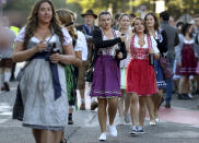 Young women arrive for the opening of the 186th 'Oktoberfest' beer festival in Munich, Germany, Saturday, Sept. 21, 2019. (AP Photo/Matthias Schrader)