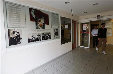 Students walk past photographs of modern Turkey's secular founder Mustafa Kemal Ataturk hanging on a wall at the entrance of FEM University Preparation School in Uskudar November 27, 2013. REUTERS/Murad Sezer