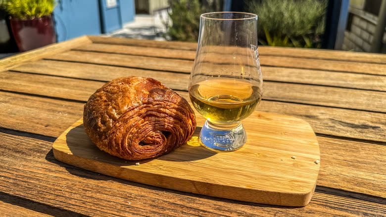 glass of whisky with chocolate croissant