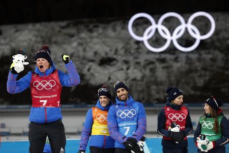 Biathlon - Pyeongchang 2018 Winter Olympics - Mixed Relay Final - Alpensia Biathlon Centre - Pyeongchang, South Korea - February 20, 2018 - Marie Dorin Habert of France celebrates winning the gold medal next to team mates Simon Desthieux and Martin Fourcade of France during the victory ceremony. REUTERS/Murad Sezer