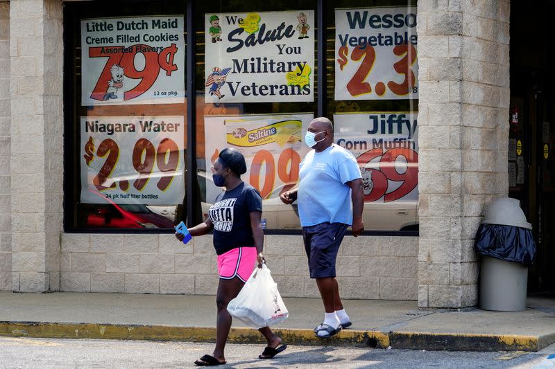 FILE PHOTO: Shoppers leave a Piggly Wiggly supermarket with a sign honoring veterans in its window in Columbus