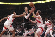 San Antonio Spurs center Victor Wembanyama (1) battles for control of the ball against Toronto Raptors forward Scottie Barnes (4) and center Jakob Poeltl (19) during first-half NBA basketball game action in Toronto, Monday Feb. 12, 2024. (Chris Young/The Canadian Press via AP)