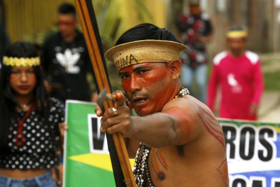 An indigenous man aims an arrow during a protest against the disappearance of Indigenous expert Bruno Pereira and freelance British journalist Dom Phillips, in Atalaia do Norte, Vale do Javari, Amazonas state, Brazil, Monday, June 13, 2022. Brazilian police are still searching for Pereira and Phillips, who went missing in a remote area of Brazil's Amazon a week ago. (AP Photo/Edmar Barros)