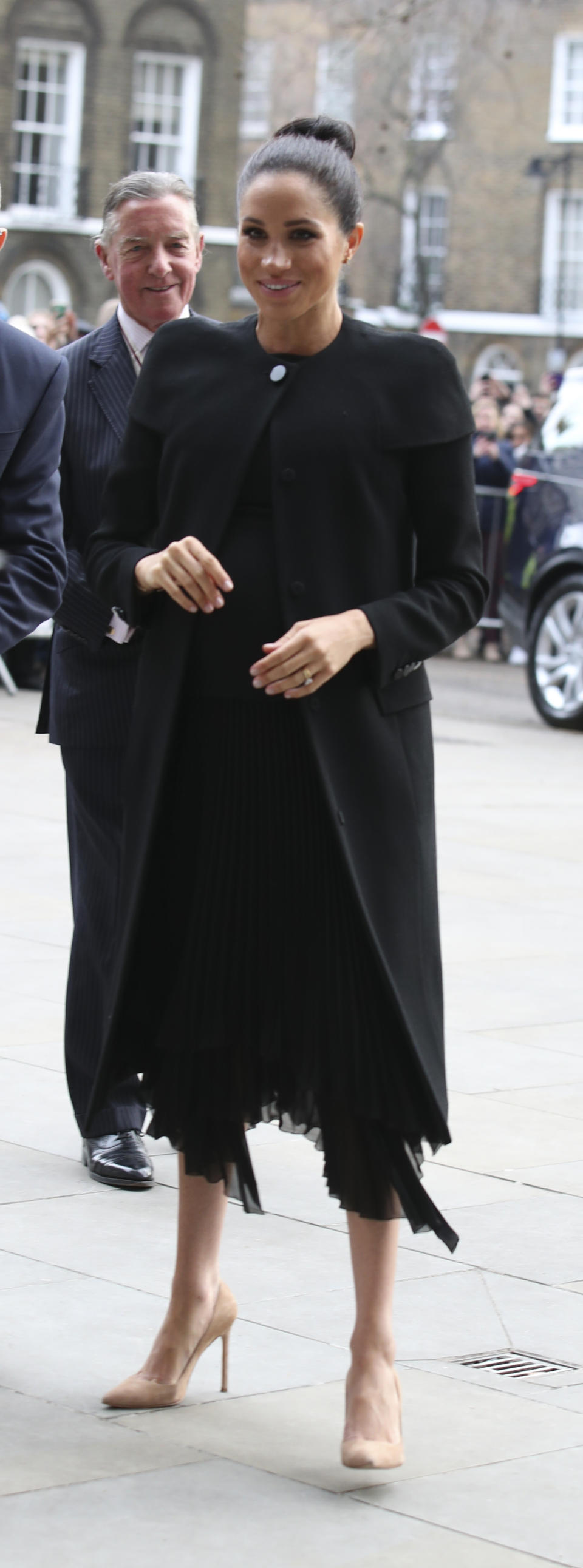 Meghan wore an all black outfit with a sleek topknot [Photo: Getty]