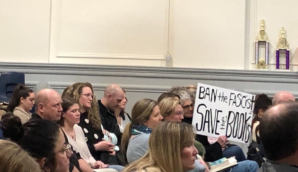An audience member displays a sign that reads "Ban the Fascists, Save the Books" in protest of the Sparta Board of Education's decision to move a novel from the middle school to the high school library during a board meeting at the Mohawk Avenue School Thursday, Feb. 23, 2023.