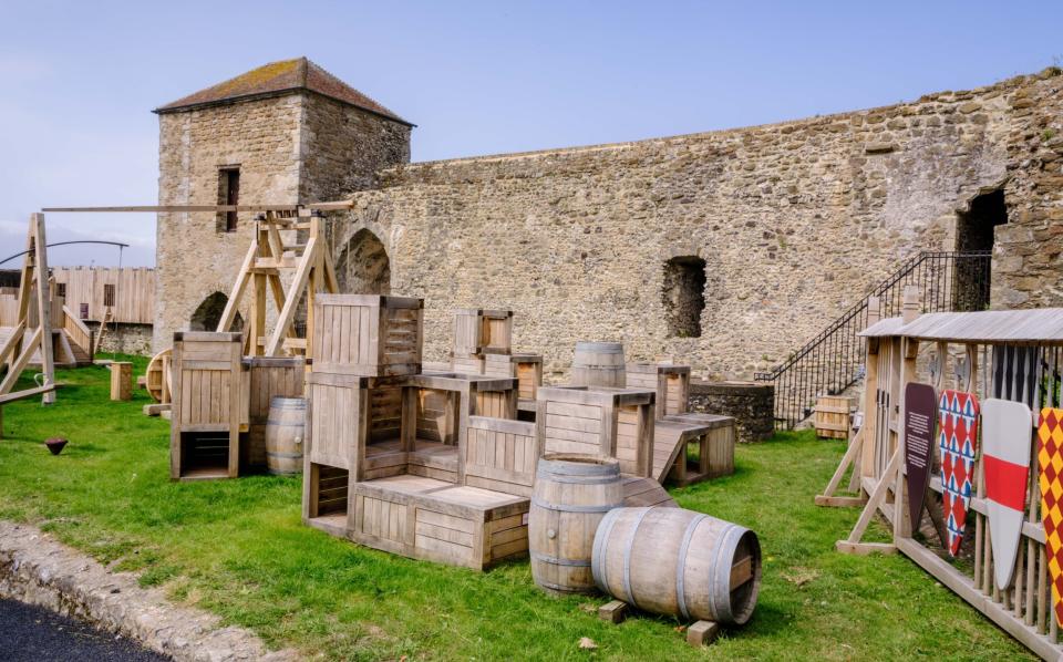 Wooden barrels and crates in the courtyard of some stone buildings