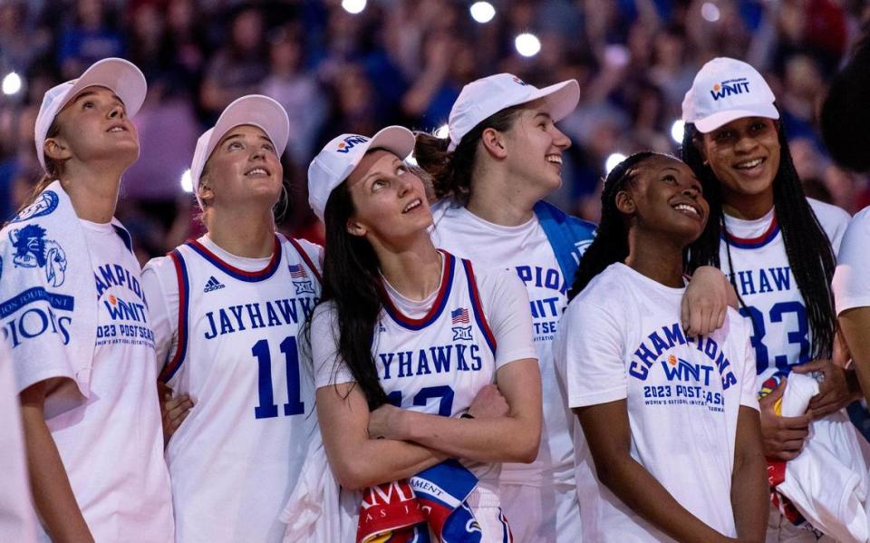 Kansas players watch a highlight reel of their WNIT tournament run after defeating Columbia 66-59 in an NCAA college basketball game in the final of the WNIT, Saturday, April 1, 2023, in Lawrence, Kan.