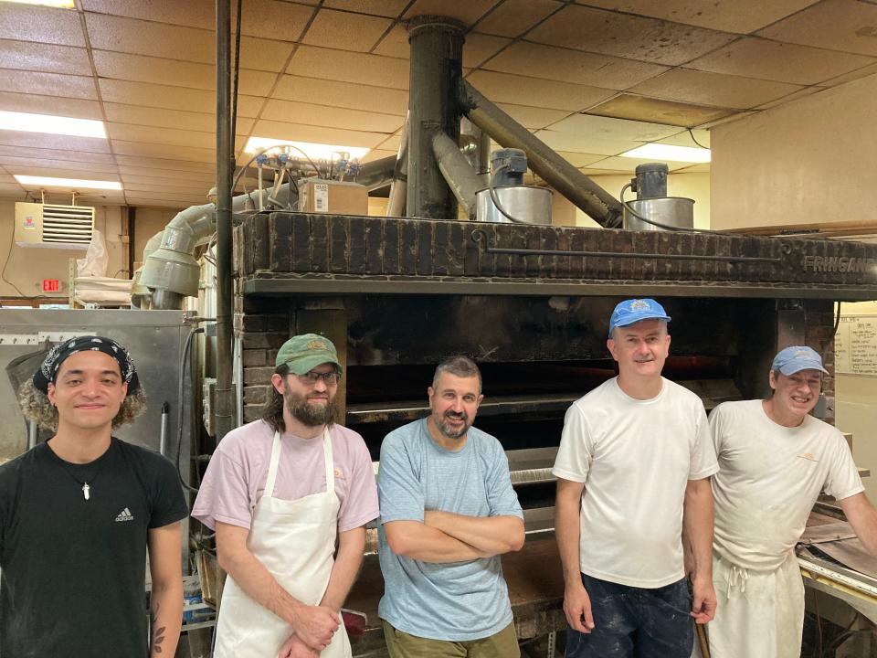 From left to right, bakers Joannic Choplin, Richard Caton, Nijaz Selic, Darko Saric and Steve Quinlan stand Aug 15, 2023 in front of the 21-ton oven at Klinger's Bread Co. in South Burlington.