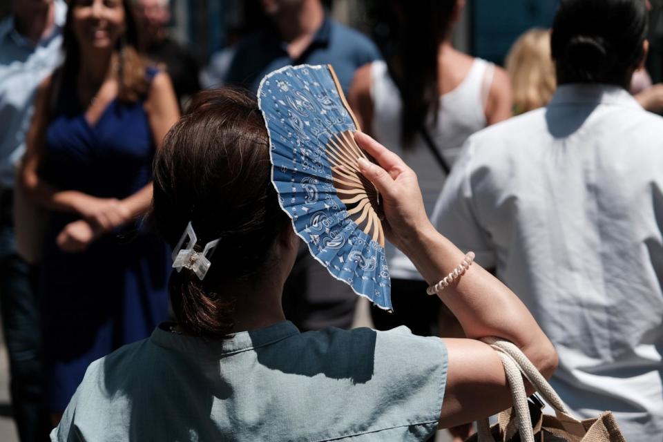 PHOTO: A woman walks with a hand fan on a hot afternoon in midtown Manhattan on July 06, 2023 in New York City.  (Spencer Platt/Getty Images, FILE)