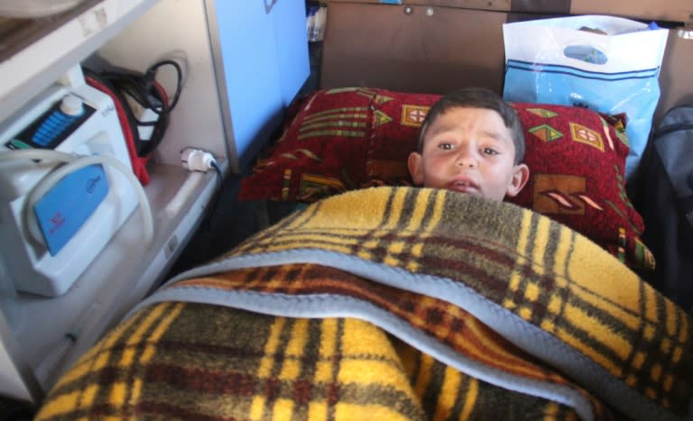 Syrian boy Abdel Basset Al-Satuf (C) is seen inside an ambulance in the town of Al-Hbeit, in northwest Idlib province, on February 17, 2017, before being transferred to Turkey for medical treatment