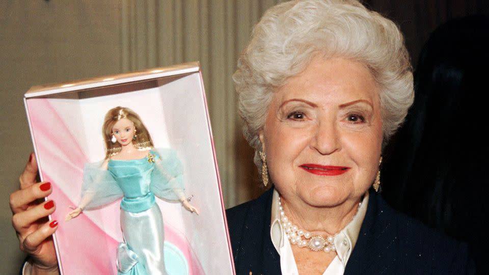 Ruth Handler, who created Barbie, holds a Barbie doll created for the 40th Anniversary party in 1999. - Jeff Christensen/Reuters