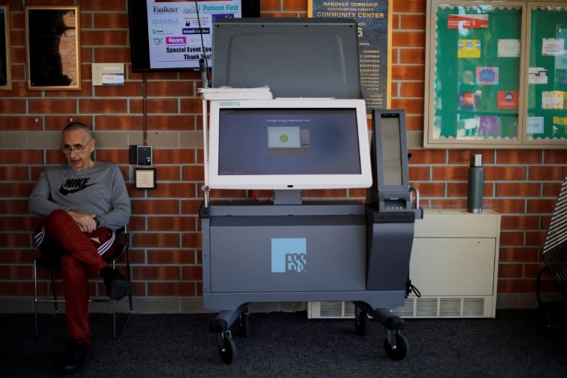 FILE PHOTO: Elections official Bernie O’Hare waits to help voters use a new Election Systems & Software ExpressVote XL voting machine in Hanover Township