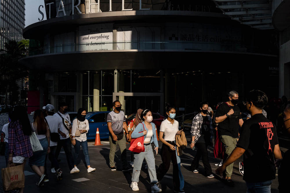 People are seen wearing protective masks as they walk along the Bukit Bintang shopping area in Kuala Lumpur on October 9, 2021. — Picture by Firdaus Latif